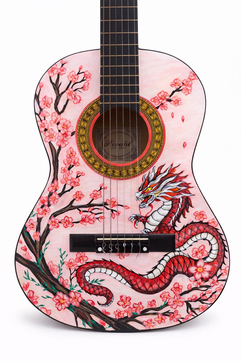 A close-up of a pink acoustic guitar with a painted dragon and cherry blossoms on the body. The dragon is red and white, a...